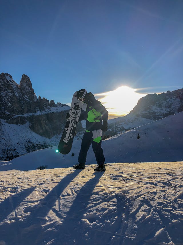 man-met-snowboard-op-besneeuwde-berg